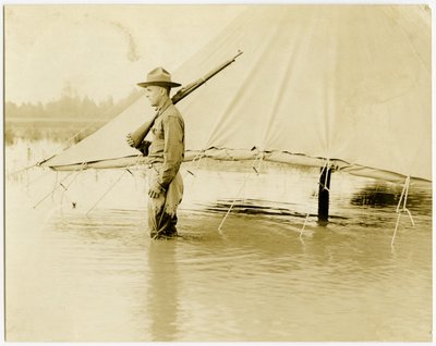 Uniformed Soldier Standing Guard in a Flooded Field by Carl Michel